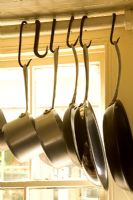 Kitchen pots and pans on meat hooks detail 
