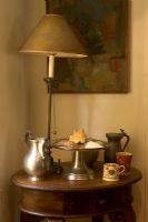 Silverware, ceramics and lamp on side table