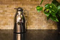 Chrome Pitcher on Black Counter in Front of Tiles