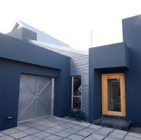 Modern home facade with a corrugated iron wall