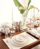 Place setting on dining table with flowers and candle sticks