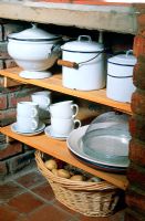 Cookery and tableware on kitchen shelves