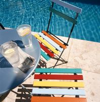 Slices of lime in glasses on table by pool