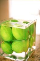Limes in a square vase full of water