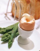 Close-up of a soft boiled egg with asparagus