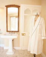 View of bathroom sink with mirror and bathrobe with mannequin