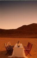 Dining table and chairs set up in the desert