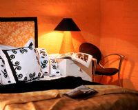 View of bed and pillows beside illuminated lamp 