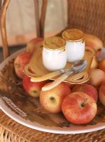 Close-up of yogurts and a platter of apples