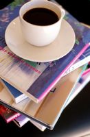 Close-up of a stack of books and a cup of coffee