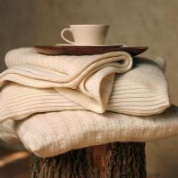 Pile of white linens with a wooden tray and coffee cup