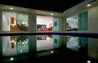 Night view in towards living room of home across pool