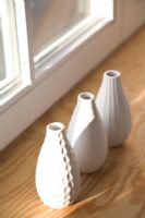 White vases on wooden windowsill 