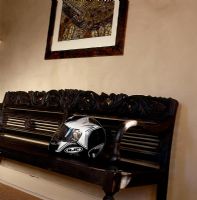 Vintage wood carved bench with a motorcycle helmet
