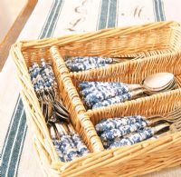 Spoons and forks in wicker basket