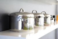 Collection of saucepans on kitchen shelf