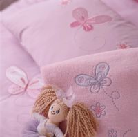 Toy doll on pink pillow, close-up