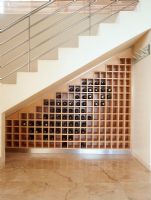 View of wine bottles on shelf under staircase
