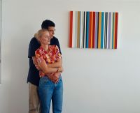 Man holding a woman next to a modern painting