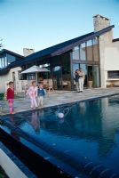 Family playing with a ball near a swimming pool