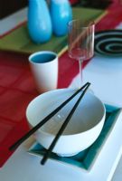 Bowl with chopsticks and glass, close-up