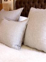 Soft grey cushions on bed