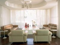 A contemporary living room with white curtains