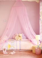 Modern girls bedroom with canopy and soft toys on bed