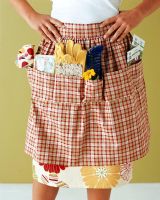 Woman wearing gardening apron, mid section