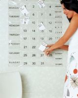 Woman sticking labels on calendar