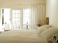 A white bedroom with a big window