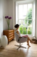Woman sitting on Arne Jacobsen 'Swan' chair