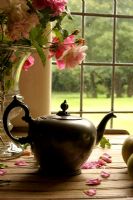 Teapot and vase of Roses on windowsill