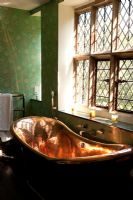 Copper bath next to lead paned window