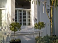 Modern Victorian exterior with plantation style shutters, topiary bay trees