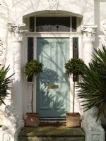 Renovated Victorian exterior with plantation style shutters, topiary bay trees