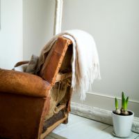Vintage leather armchair with wool throw