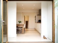 Contemporary kitchen with porcelain tiled flooring viewed through bi-fold doors