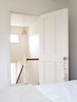 Bedroom door open to white hallway