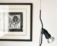 A contemporary white and black drawing on the wall and a lamp