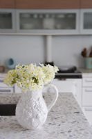 Jug of flowers on kitchen worktop