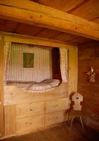Built in wooden bed in country bedroom 