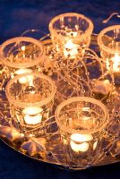 Tray of candles in decorative glasses 