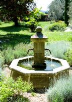 Traditional stone water well in country garden