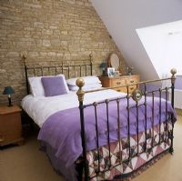 Modern bedroom with exposed stone wall
