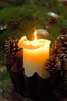 Church candle and decorative pine cones