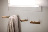 Rustic wooden towel hooks in bathroom 