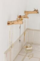 Jewelery hung on rustic wooden hooks  