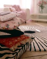 Pile of patterned cushions on floor, detail 