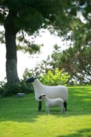 Modern sheep and lamp sculptures in garden 